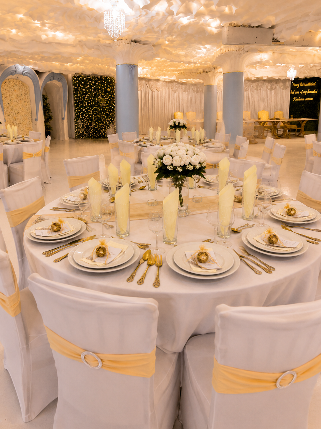 Wide view of the Opulent @ 35 Liverpool banquet hall with cream napkin fans, gold cutlery and an illuminated floral backdrop