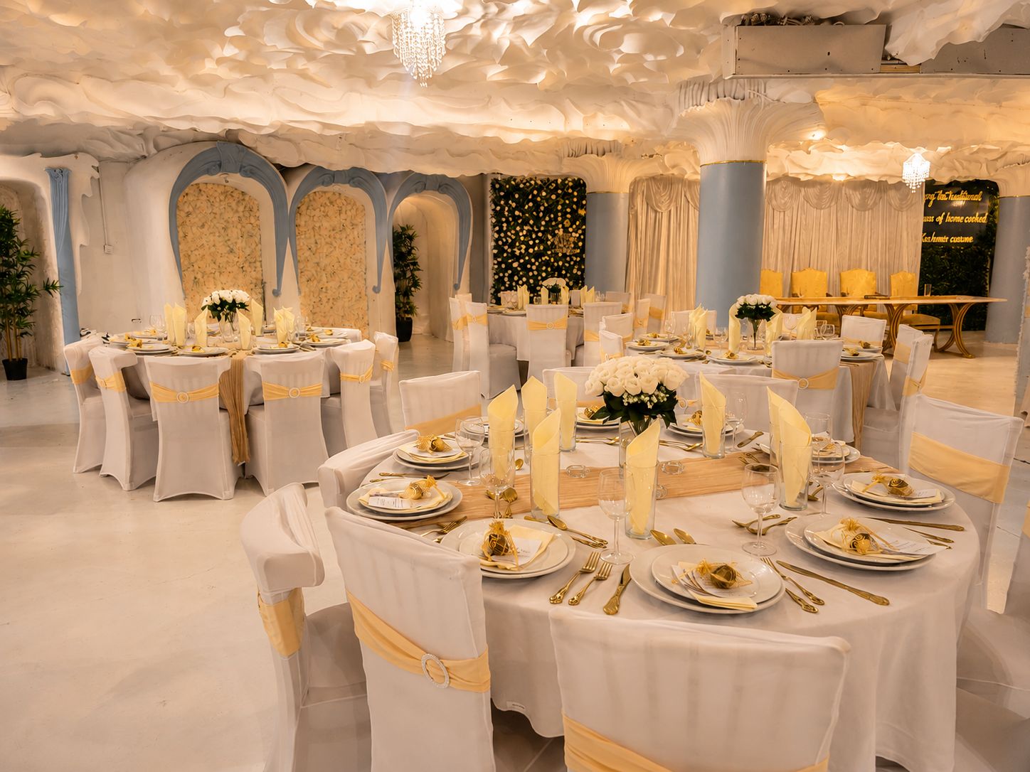 Wide view of the Opulent @ 35 Liverpool ballroom dressed for a wedding with gold drapery, white roses and pale blue Art Nouveau arches inside the Grade II listed Liverpool city-centre venue